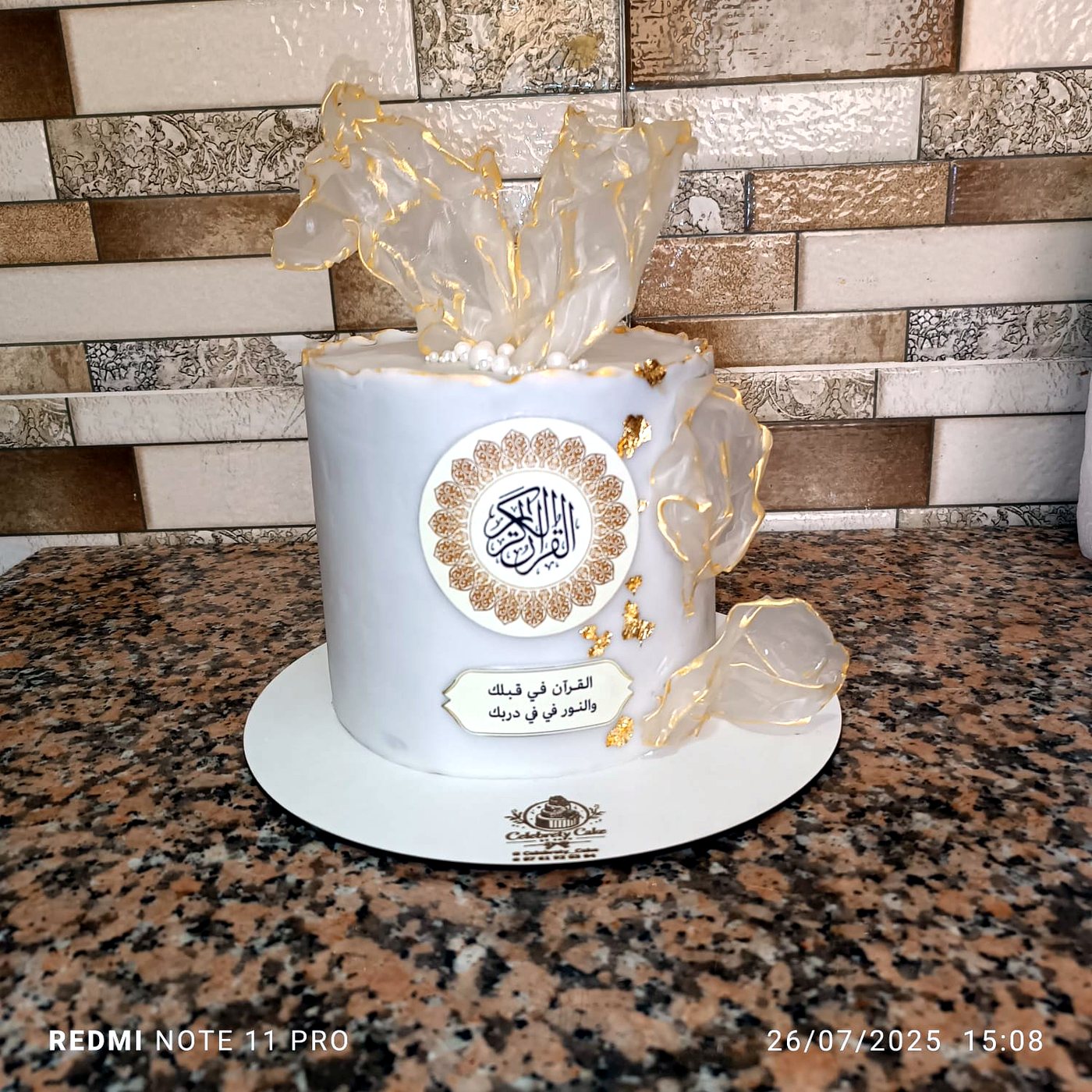 Gâteau blanc et or avec nœud sur marbre